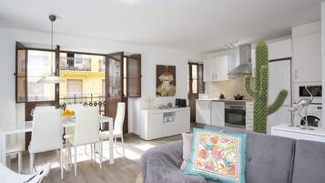 Un appartement moderne comprenant un coin repas, une cuisine et un salon.