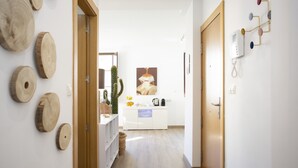A hallway with a wooden door, a white cabinet, and a cactus decoration. - SingularStays Valencia Center III (València)