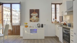 A modern kitchen with a central island, a built-in oven, and a view of the city through large windows. - SingularStays Valencia Center III (València)