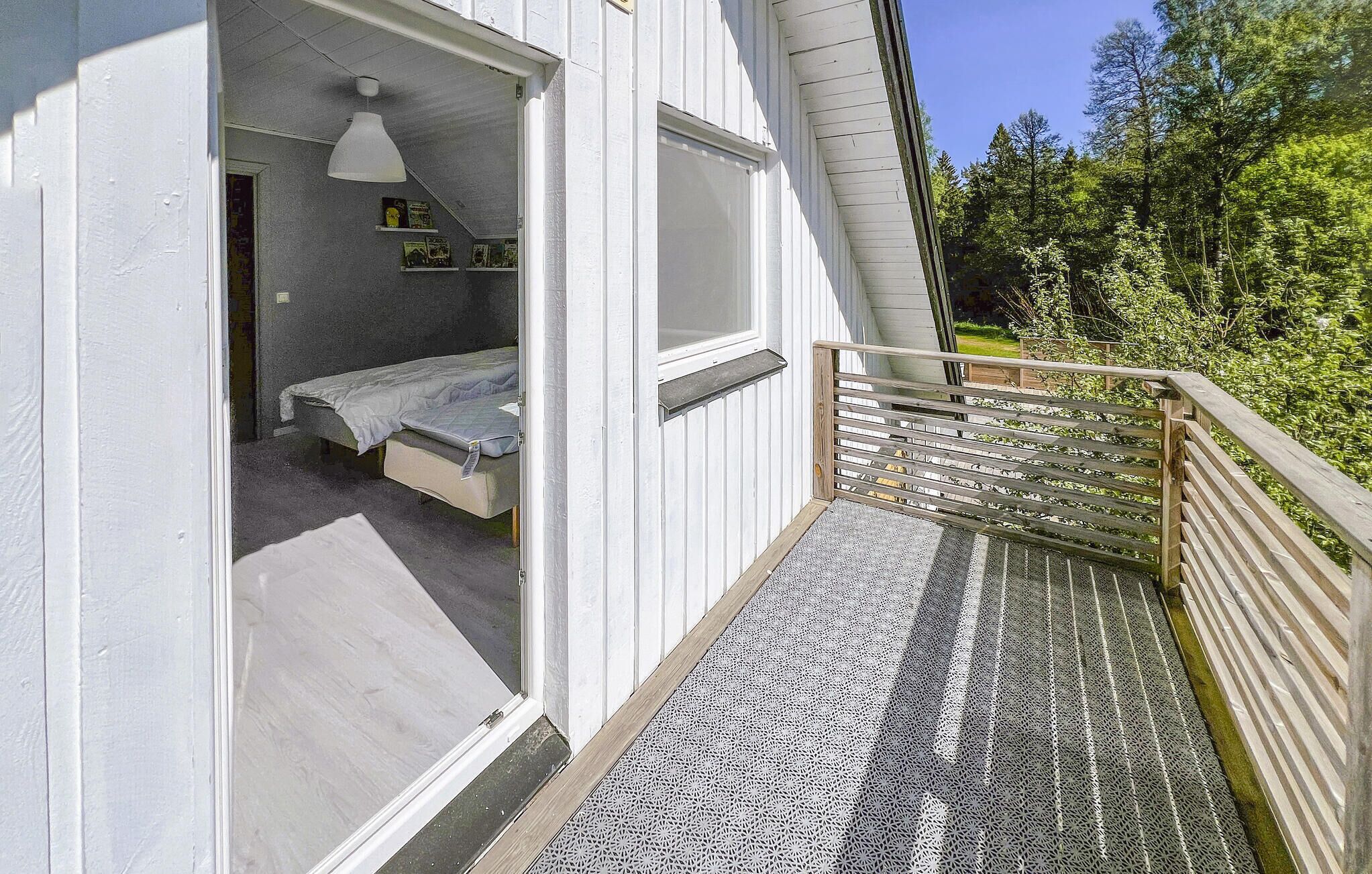 Ein Schlafzimmer mit Bett, einer Hängeleuchte und einem Fenster.