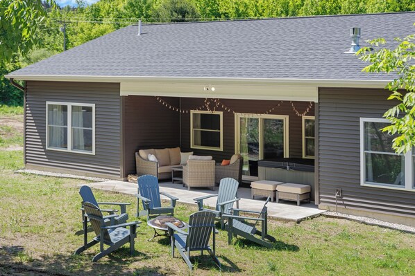 A house with a covered patio area featuring outdoor furniture and a fire pit.