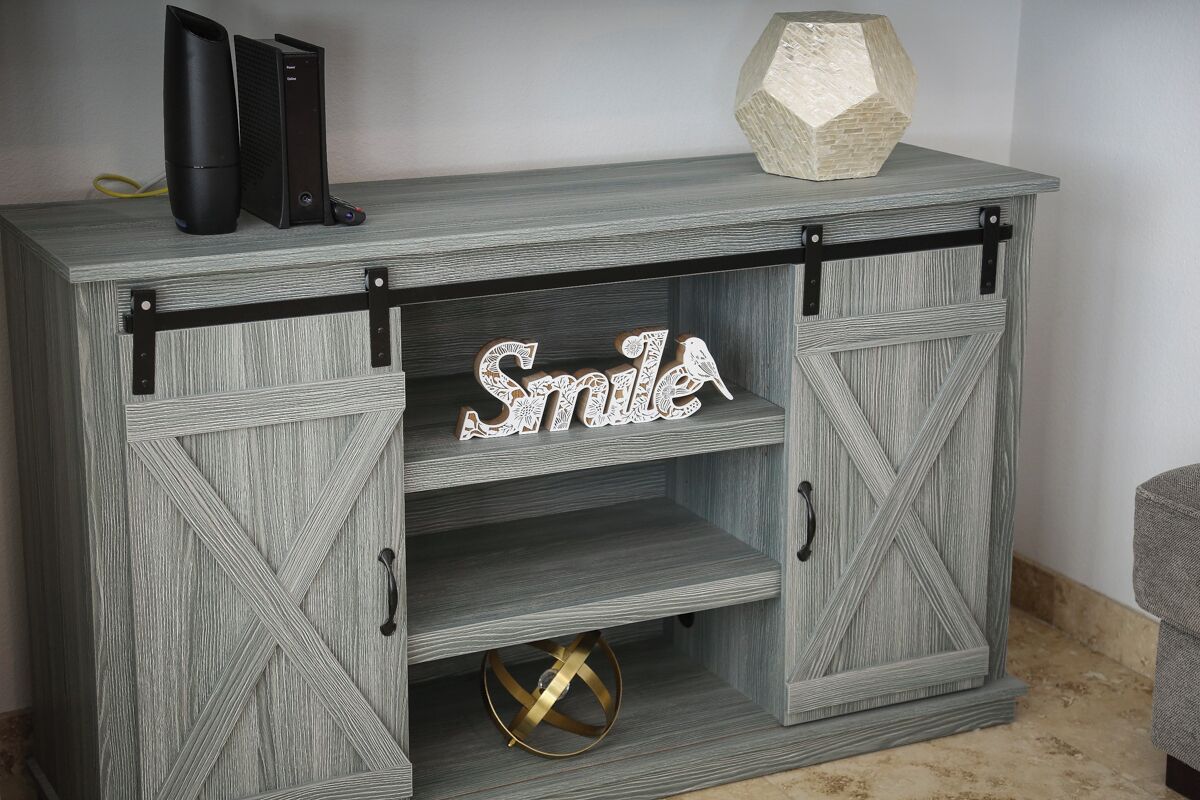 A wooden cabinet with a rustic design, featuring a 'Smile' sign and a decorative bird.