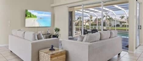 A modern living room with two sofas, a coffee table, and a TV.