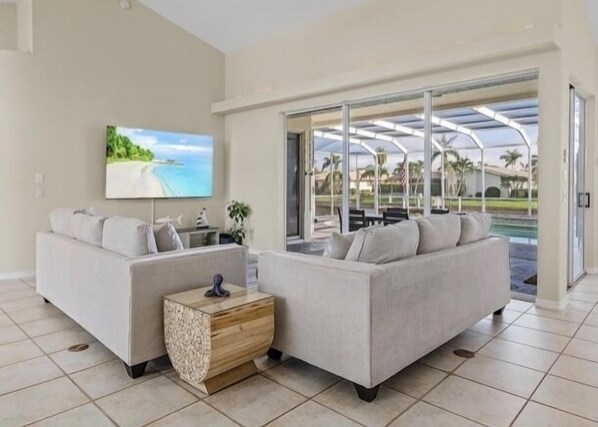 A modern living room with two sofas, a coffee table, and a TV.