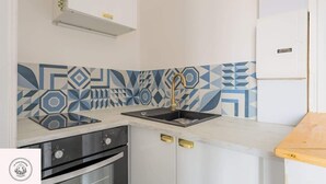 A kitchen with a modern design, featuring a patterned backsplash, a built-in oven, and a stainless steel sink. - Le duplex inverse, Bollaert, Fac, gare, 2pers (Lens)