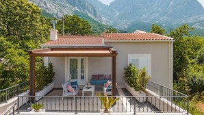A modern house with a covered patio, a sofa, and a table. - Stunning home in Bast (Bast)