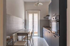 Una cocina compacta con comedor, estufa y refrigerador.