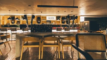 Un interior moderno con una zona de bar, sillas de madera y un cartel que dice