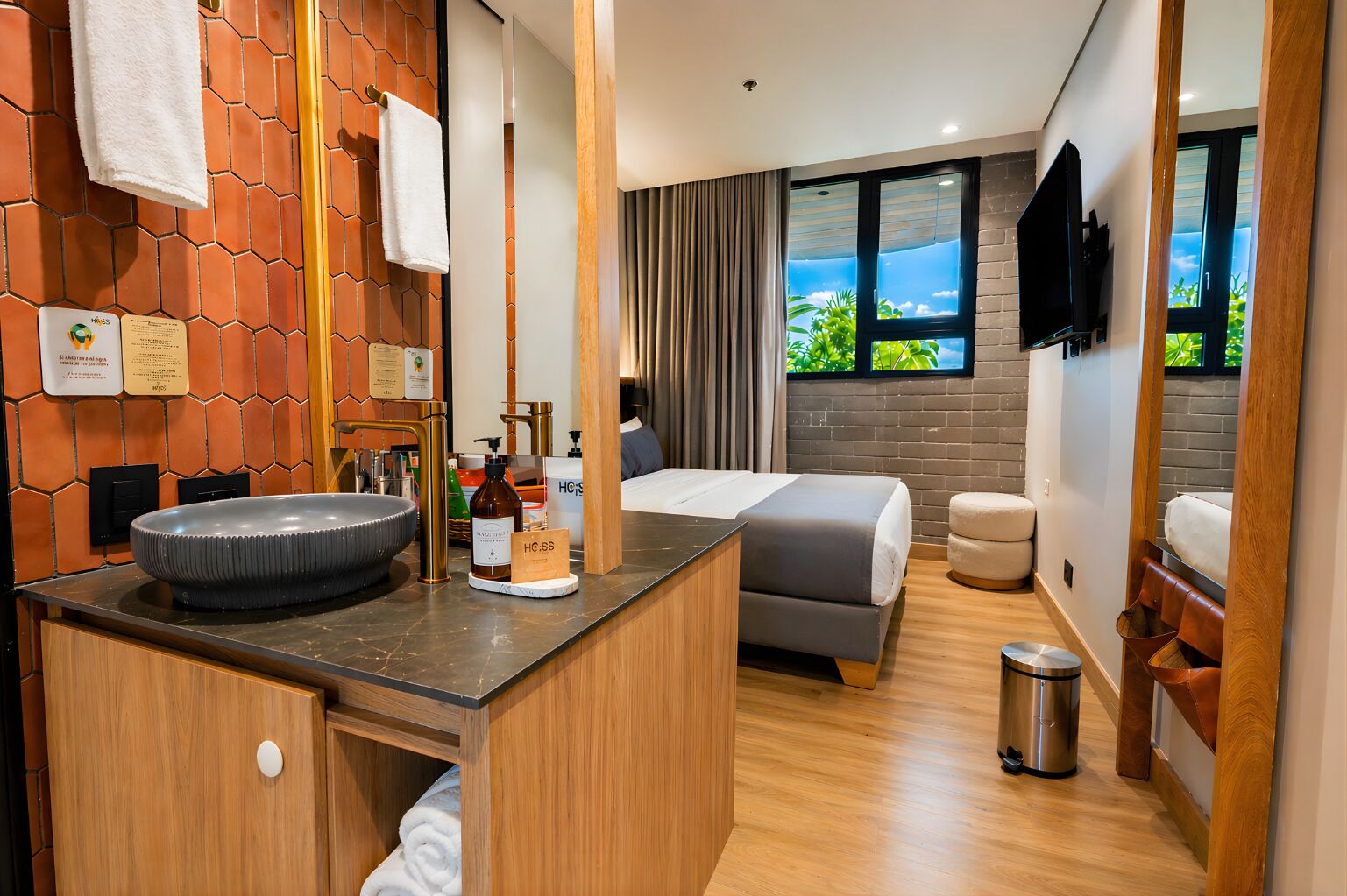 A hotel room with a large sink, a bed, a small seating area, and a window with a view.