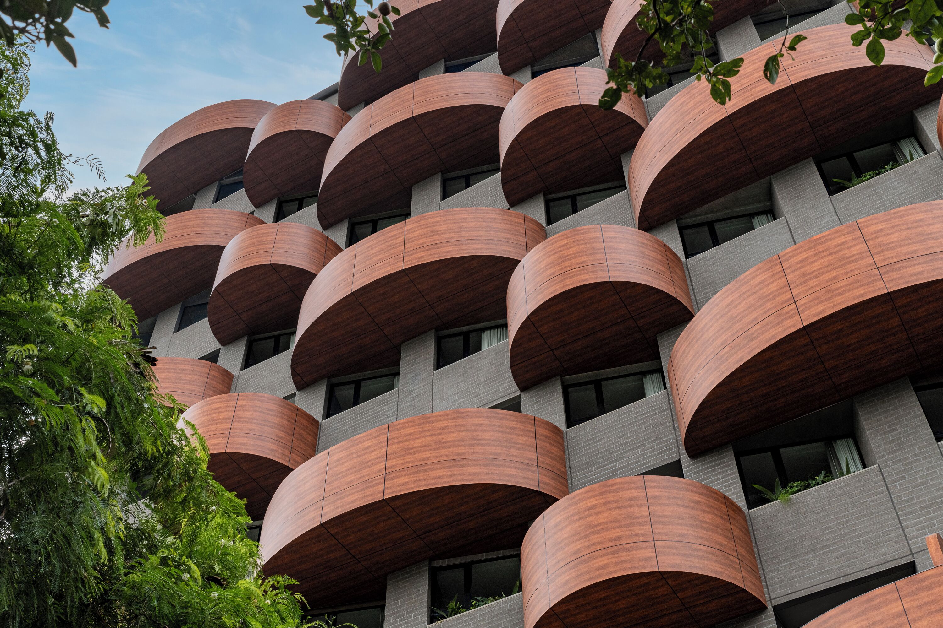 Un edificio moderno con varios balcones y fachada de ladrillo.