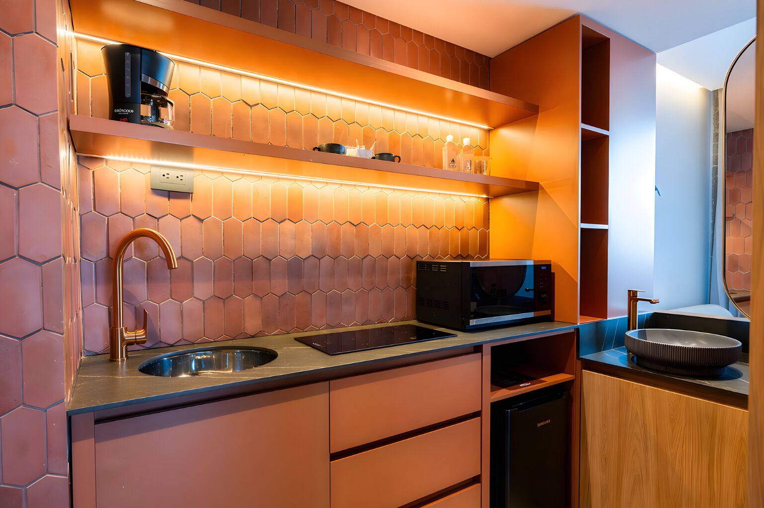 A modern kitchen with a coffee machine, microwave, sink, and wooden cabinets.