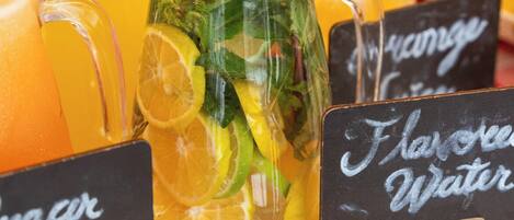 A selection of beverages including orange juice, iced tea, and flavored water, with labels indicating their names.