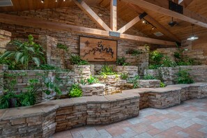 A rustic interior with exposed wooden beams, stone walls, and a variety of indoor plants. - Pet-Friendly Holiday Hills Condo w/ Pools + Golf | (HHK-7) (Branson)