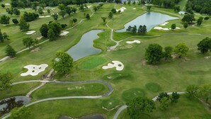 Vue aérienne d’un parcours de golf avec de nombreux étangs, des bunkers de sable et des chemins sinueux.