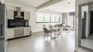 Una cocina moderna con comedor, ventanas amplias y vistas a la ciudad.