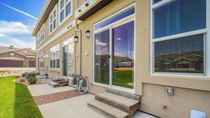 A modern two-story house with large sliding glass doors, a well-maintained lawn, and a concrete driveway. - Mid-Brambleberry (Colorado Springs)