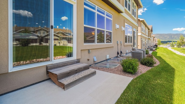 A modern building with large windows, a well-maintained lawn, and outdoor air conditioning units. - Mid-Brambleberry (Colorado Springs)