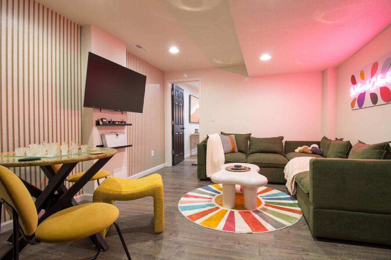 A modern living room with a sofa, a coffee table, and a TV mounted on the wall.