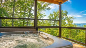 A hot tub with a wooden deck and a view of a forested landscape. - Mountain Dreams - Mountain views for miles! (Sevierville)