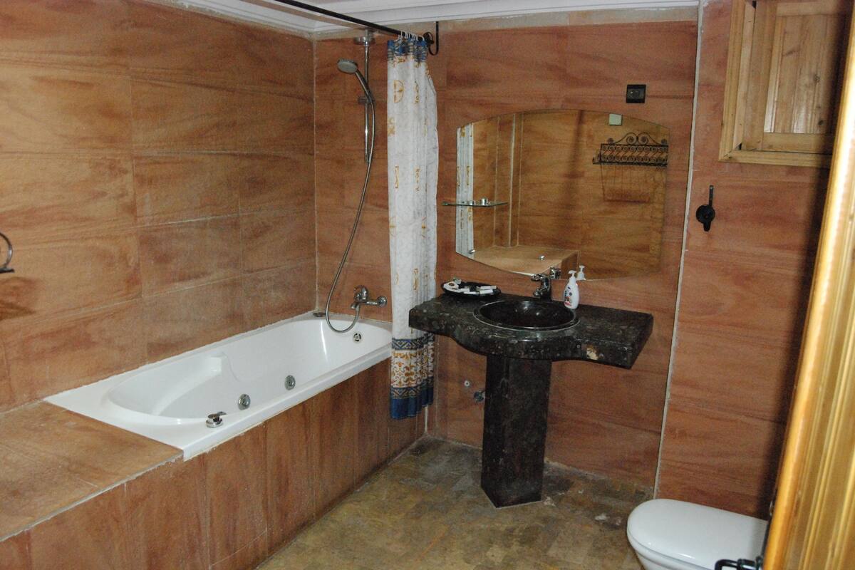 Um banheiro com banheira, pia e vaso sanitário.