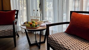 Una habitación con una mesa de comedor para dos personas, un frutero y una botella de agua.