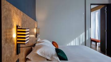 Habitación de hotel moderna con una cama grande, cabecera de madera y vistas al exterior.