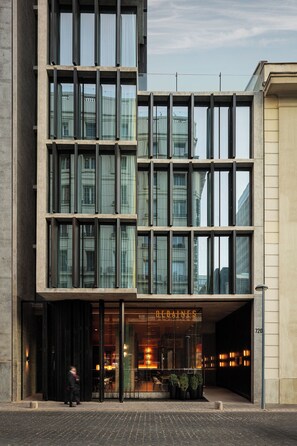 Un edificio moderno con fachada de vidrio y un cartel que dice "DEBAINES".