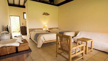 A room with two beds, a sofa, a chair, and a small table.