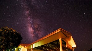 A building with a covered entrance, a visible staircase, and a view of the Milky Way. - VILLA  UNARIZAKI (Taketomi)