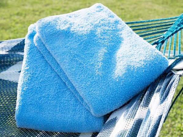 A hammock chair with a blue towel draped over it. - VILLA UNARIZAKI (Taketomi)