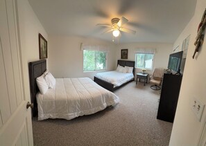 A bedroom with two beds, a ceiling fan, a small table with a lamp, and a TV on a stand. - Lake Winnebago Water Front! Fishing! Boating! Quiet Bay! EAA! (Oshkosh)