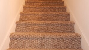 A carpeted staircase with a wooden handrail, leading to a door at the top. - Lake Winnebago Water Front! Fishing! Boating! Quiet Bay! EAA! (Oshkosh)