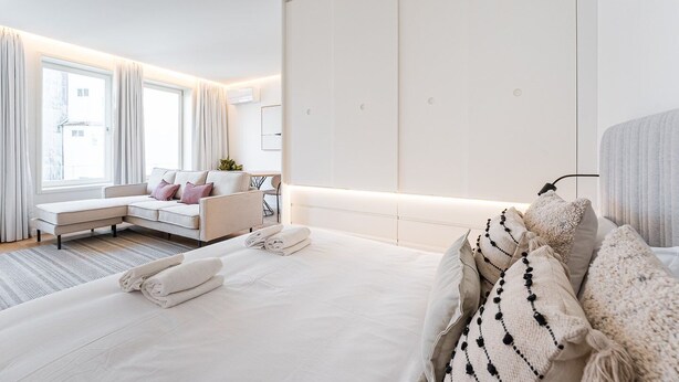 Une chambre d’hôtel moderne avec un grand lit, un canapé et un bureau.