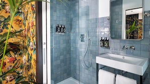 A bathroom with a shower, sink, and mirror.