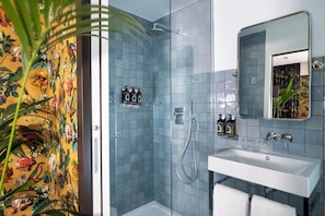 A bathroom with a shower, sink, and mirror.