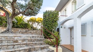 Un escalier en pierre mène à un bâtiment blanc dont la porte est marquée du numéro « 24 ».