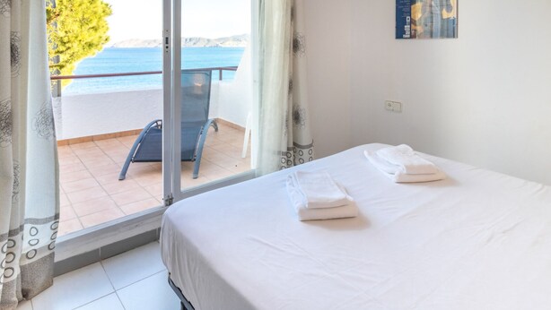Une chambre d’hôtel avec un lit, une chaise et une vue sur la mer.