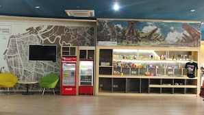 Una habitació amb un mapa a la paret, un refrigerador Coca-Cola, màquines expenedores i una presentació de llaminages i begudes.