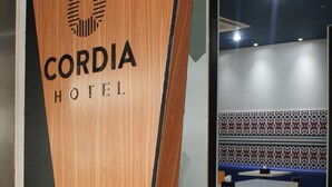 Una taula de recepció de fusta amb la frase "CORDIA HOTEL" i la paraula "WELCOME".