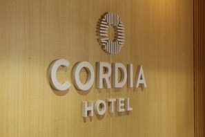 Ein Schild für das Cordia Hotel mit einem kreisförmigen Logo über dem Schriftzug.