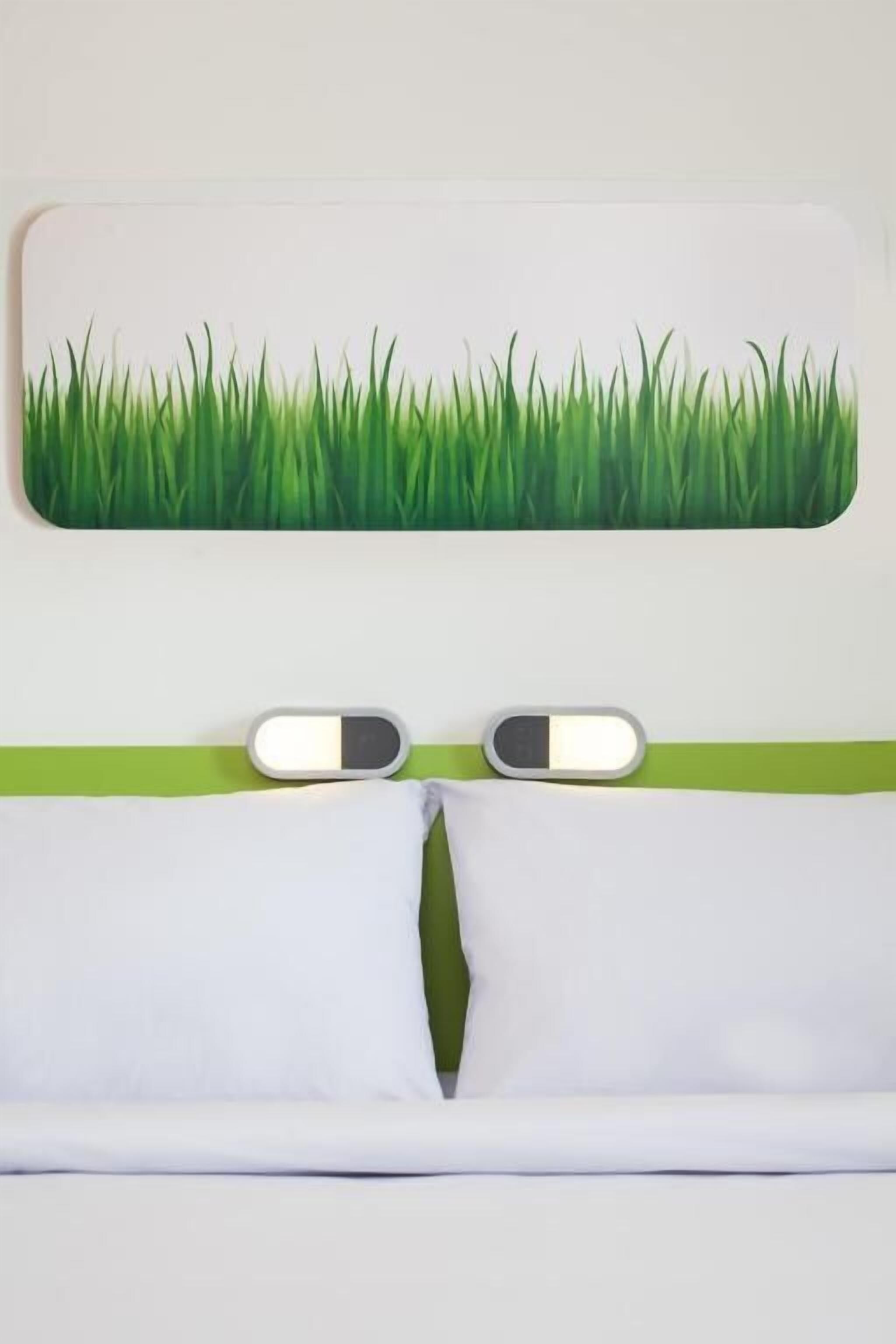 Una ventana con un motivo de césped, una franja verde y dos interruptores de luz.