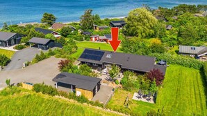 Ein Wohngebiet mit Häusern, einer Solaranlage auf einem Dach und Blick auf das Meer.