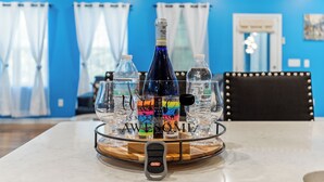 A bar area with a bottle of water, glasses, and a bottle of alcohol on a tray. - Stylish & Central Townhome in the Heart of Raleigh (Raleigh)