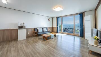 A modern living room with a sofa, coffee table, and a view of the outdoors.