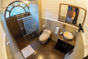 A modern bathroom with a glass-enclosed shower, a toilet, and a sink with a marble countertop. - QUINTA LOS JUANES (Baños de Agua Santa)