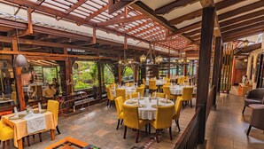 A restaurant with wooden beams, yellow chairs, and tables set for dining. - QUINTA LOS JUANES (Baños de Agua Santa)