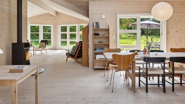 Une pièce spacieuse avec une grande table en bois, des chaises, une bibliothèque et une cheminée.