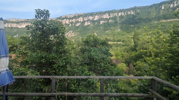 Una terraza de madera con vista a un paisaje montañoso.