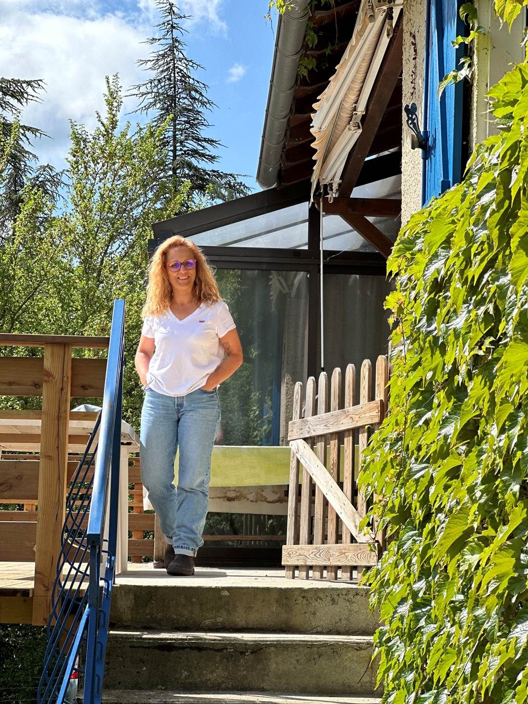 A person walking on a wooden deck with a metal gate and a wooden fence.