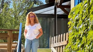 A person walking on a wooden deck with a metal gate and a wooden fence.